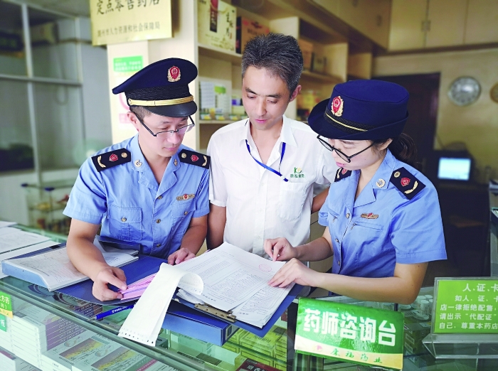 执法人员在一家药店检查特殊药品进货台账。