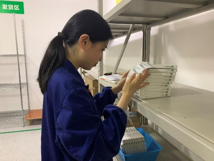 图为金华市中心医院工作人员将追溯二维码粘贴到医疗器械包装盒上。何璇 摄