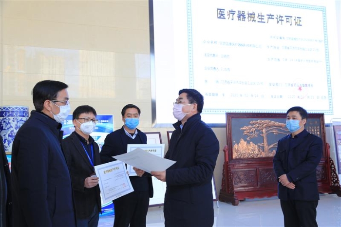 图为甘肃省药监局副局长王宗伟（右二）为三家企业发放临时《医疗器械注册证》和《医疗器械生产许可证》 （中国食品药品网记者丁怡媛 摄）