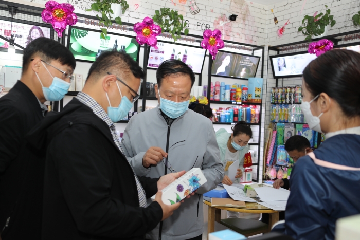自治区药监局党组书记、局长张钰祥（右二），党组成员、副局长刘洪彬（左二）一行在伊犁州巩留县检查化妆品经营门店。 马少宾摄_wps图片