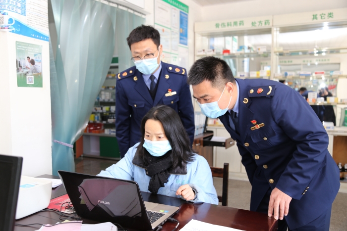 图为执法人员在查看进货台账