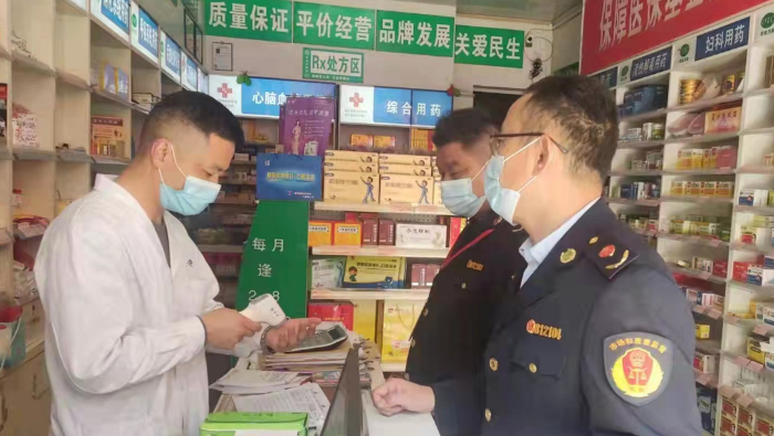 图为执法人员在一家药店检查。