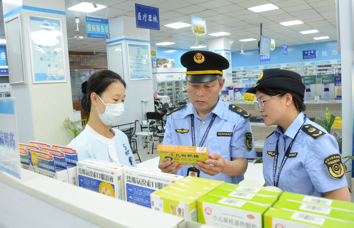 图为该局执法人员在一家药品经营企业检查儿童用药销售购进情况。
