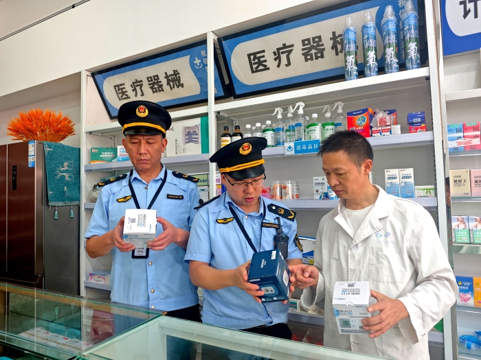 图为10月12日，该局执法人员在一家医疗器械销售单位通过检查血压仪的标签标识核查医疗器械质量。 （李朽 文光辉）